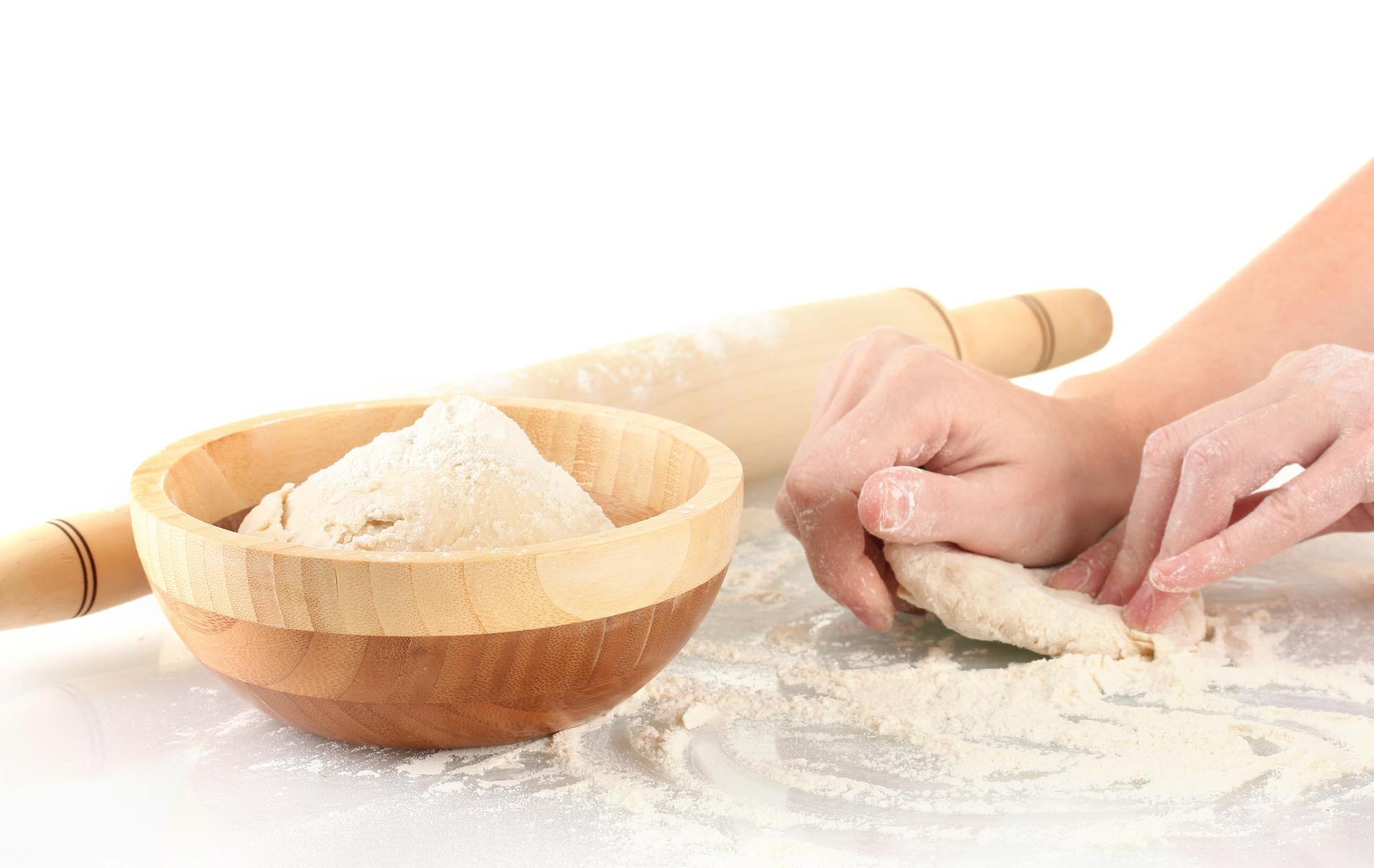 Studente che impasta su tavolo di legno